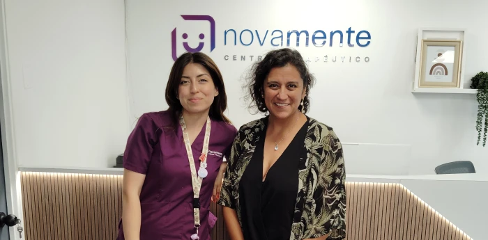 Dos especialistas de Novamente sonriendo en la recepción de la oficina en Pedro de Valdivia, Providencia.
