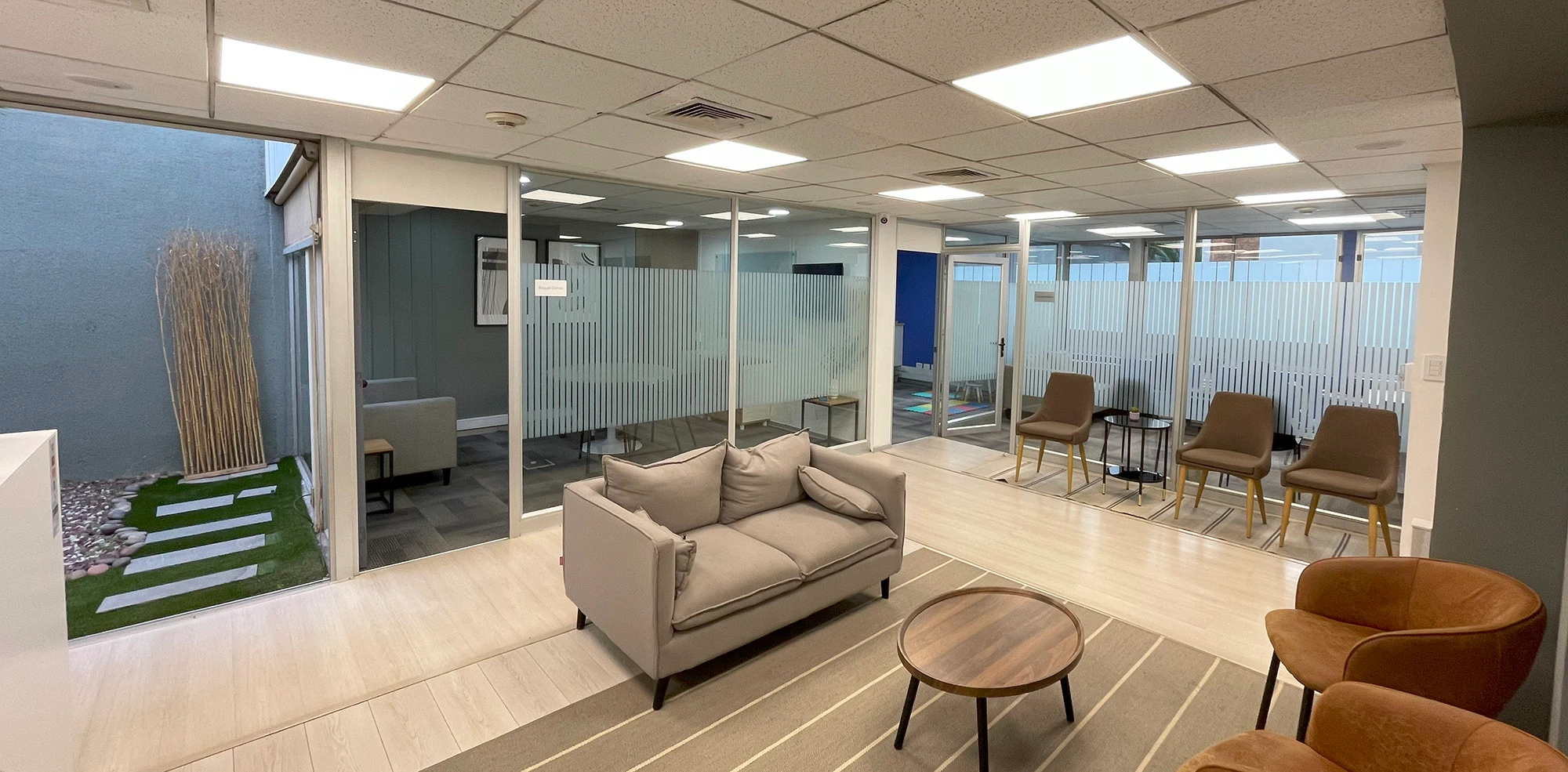 Vista de la sala de espera en Pedro de Valdivia con mobiliario moderno y ambiente profesional en Santiago.