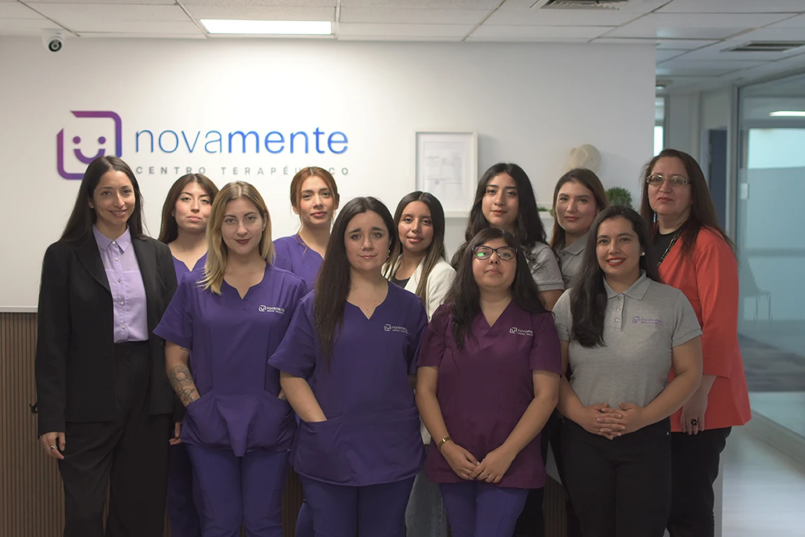Grupo amplio de profesionales de salud posando en el pasillo de las oficinas de Novamente en Providencia.
